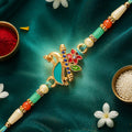 Teal Peacock Enamel Pendant Rakhi with Kundan Flower Accent