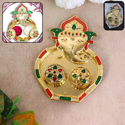 A golden Ganesh pooja thali with two small round containers, accented with red and green enamel details.