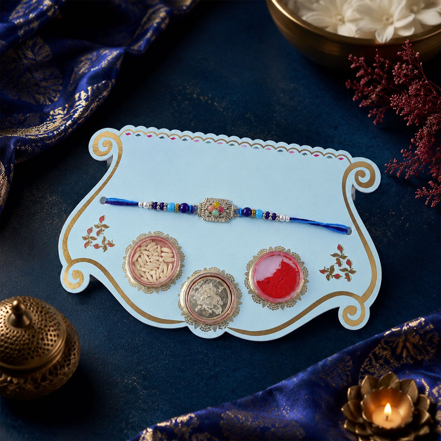 Silver Floral Stone Rakhi with Royal Blue Thread, Roli Chawal Coin and Card Gift Packing