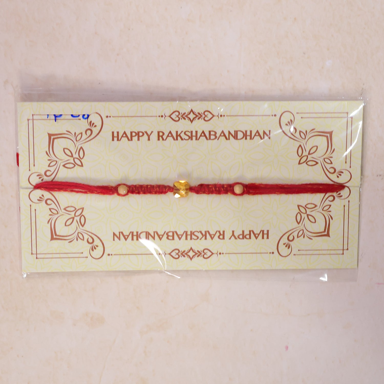Red Thread Rakhi with a Faceted Amber-Toned Crystal Cube Bead