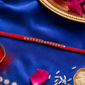 Red Thread Rakhi with a Row of Sparkling Crystal Rhinestone Beads