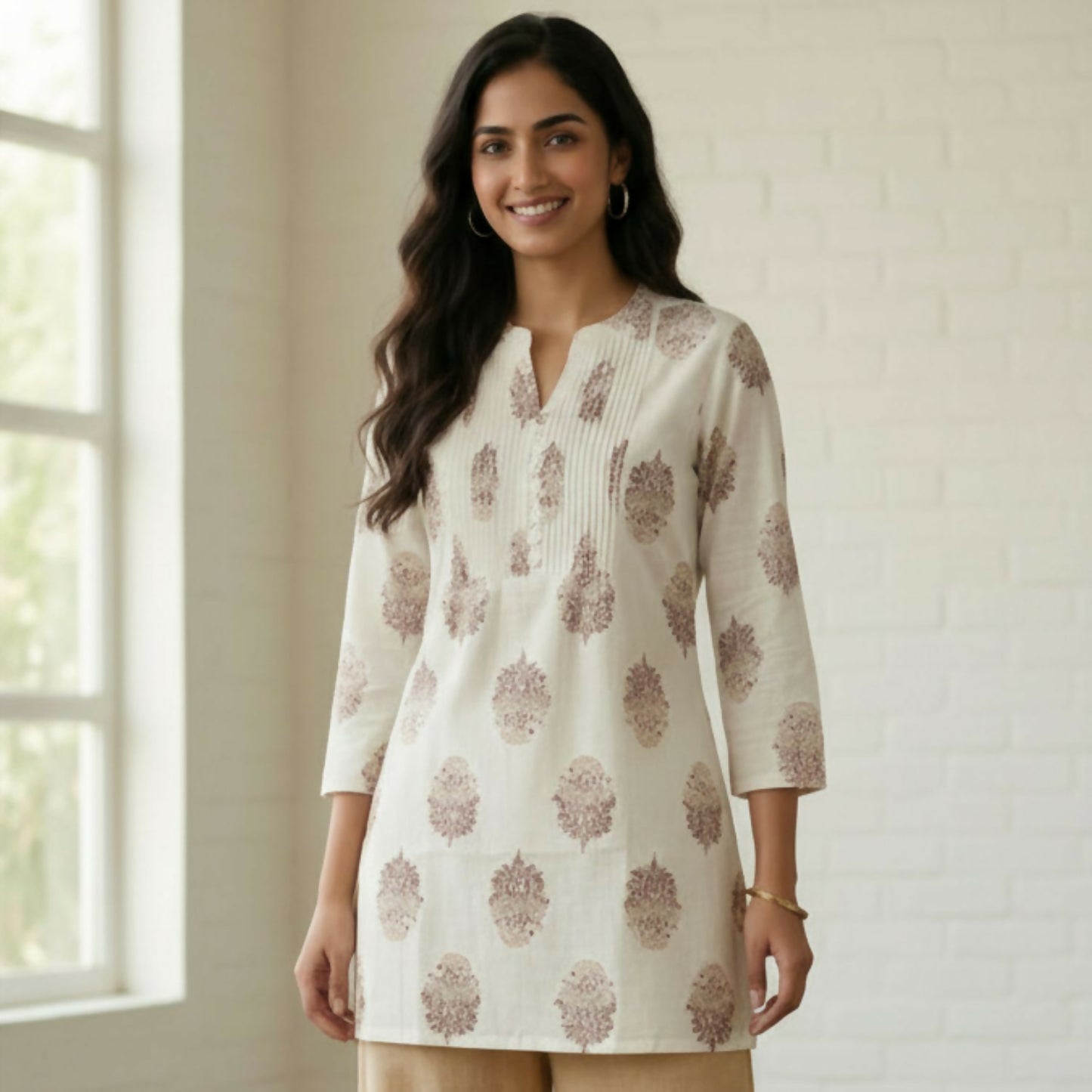 Women’s white cotton printed short kurti showcased with side slits and 3/4 sleeves
