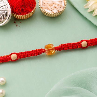 Red Thread Rakhi with a Faceted Amber-Toned Crystal Cube Bead