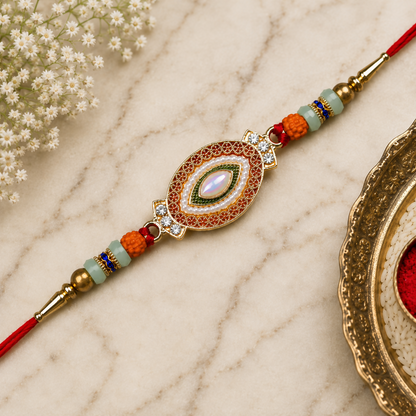 A decorative bracelet with a central oval design, featuring a white stone and colorful beads, rests on a light brown marble