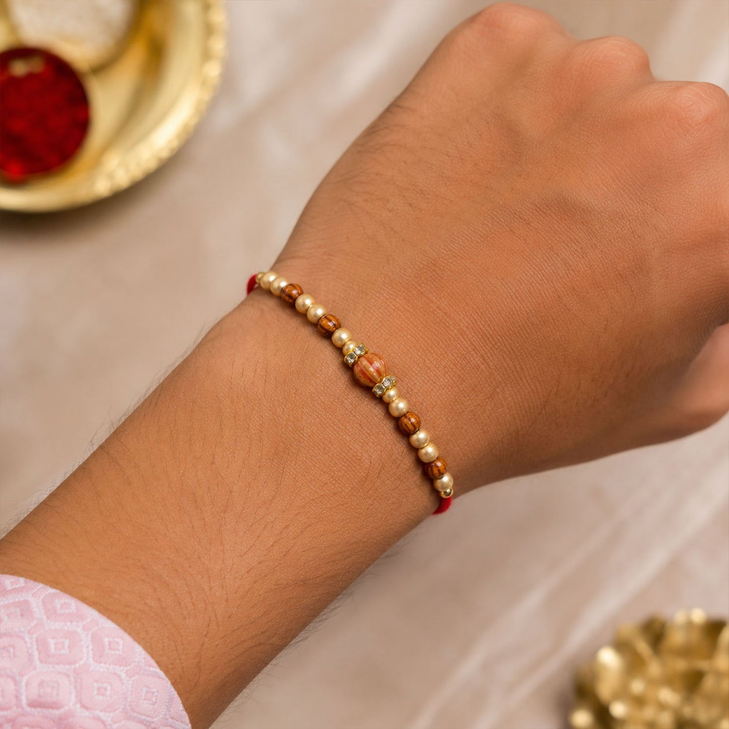 Red Thread Rakhi with Wooden Bead Pendant and Golden Bead Accents