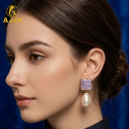 Close-up view of handcrafted pearl Tilak earrings with gold-tone frames