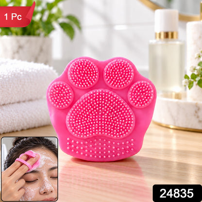 A small inset image shows a person using the pink paw-shaped facial scrubber to clean their face.