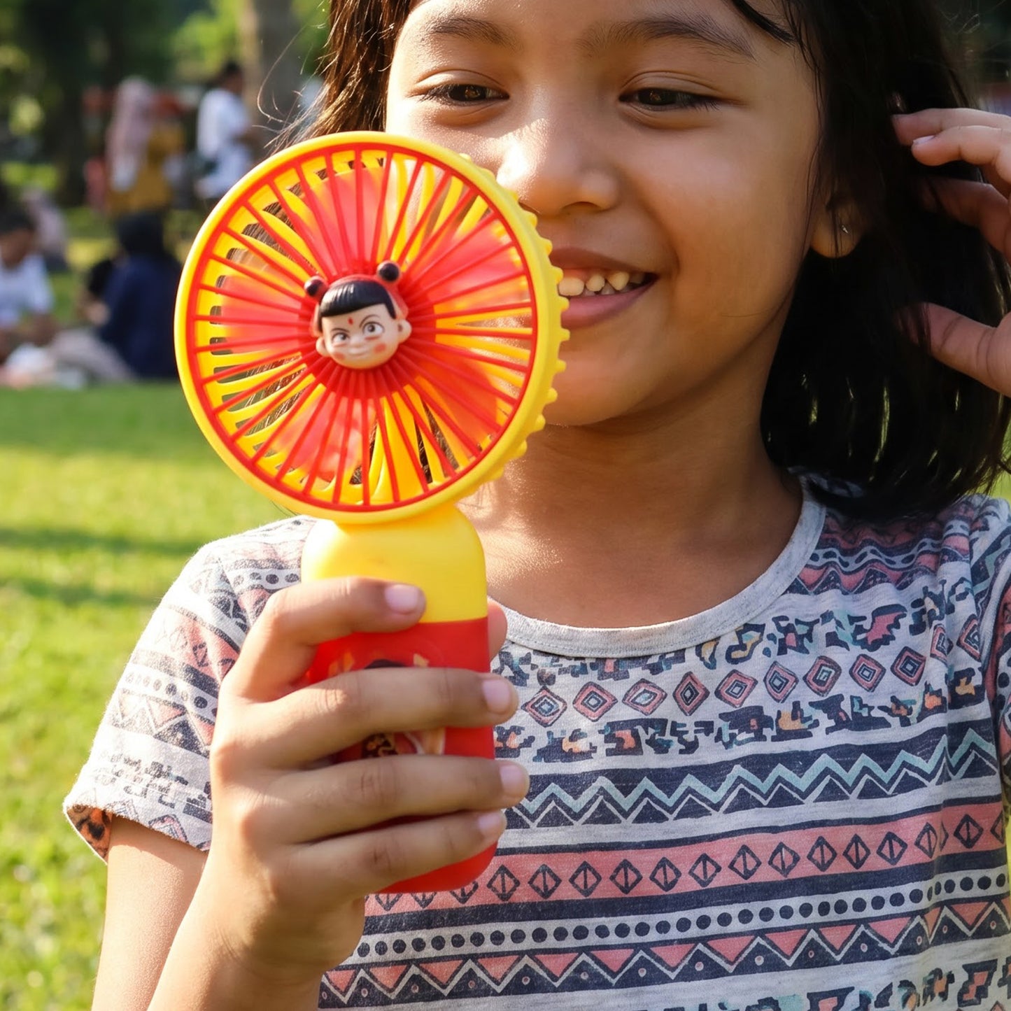 Portable fan held during outdoor use