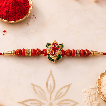 Ganesh Rudraksha Beads Rakhi with intricate gold finish on a plain background.