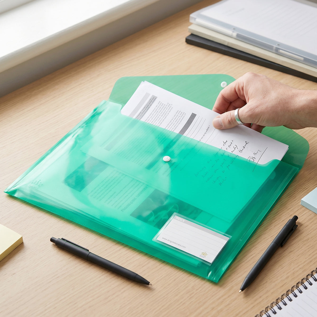 Plastic document folder open while inserting papers
