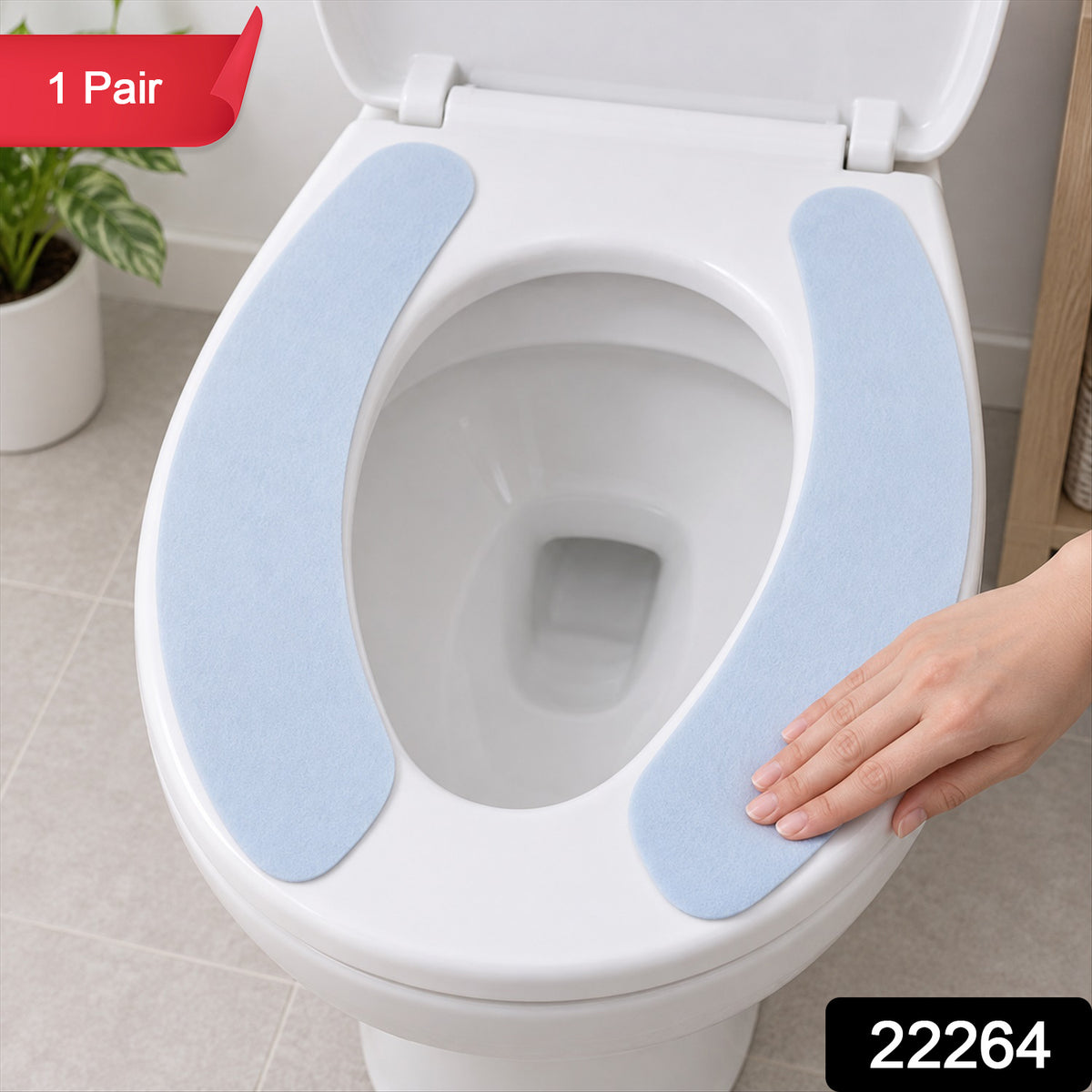 A pair of light blue toilet seat pads are placed on a white toilet, with a hand gently touching one.