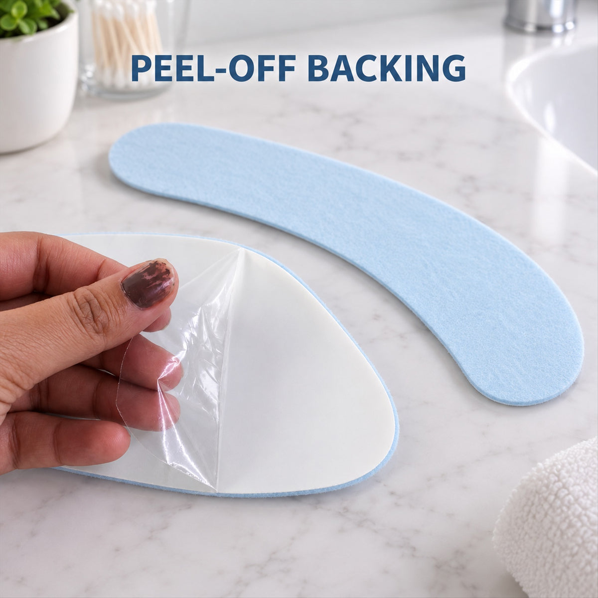 A hand peels the clear backing from a light blue fabric pad, revealing the adhesive surface.