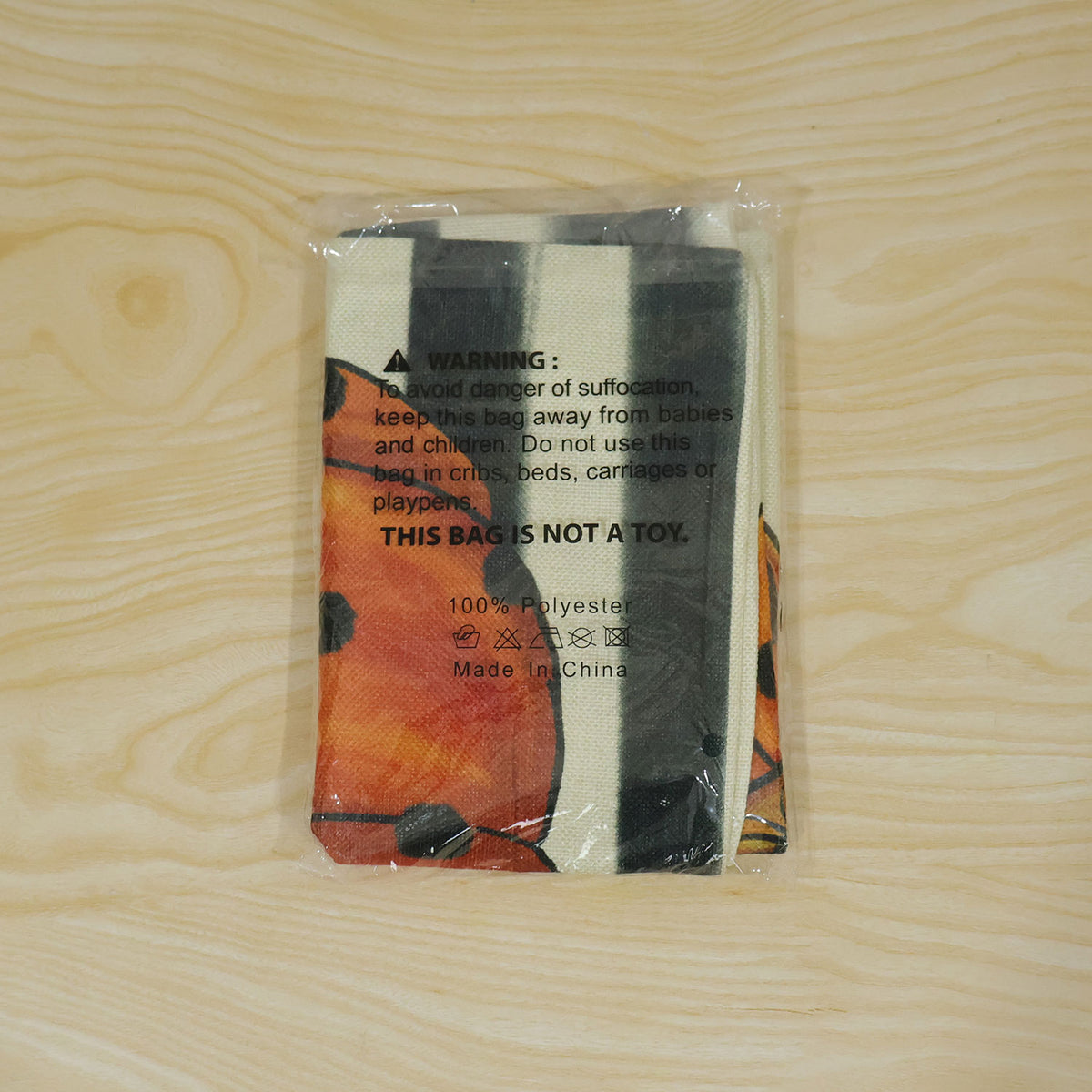 Live photo of pumpkin print pillow cover in loose plastic packing