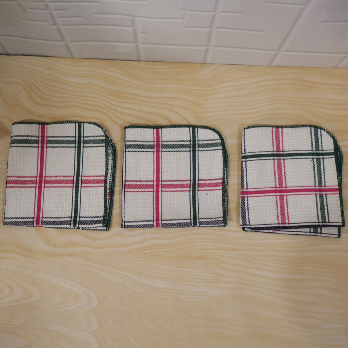 Actual photograph of three folded checked dish cloths