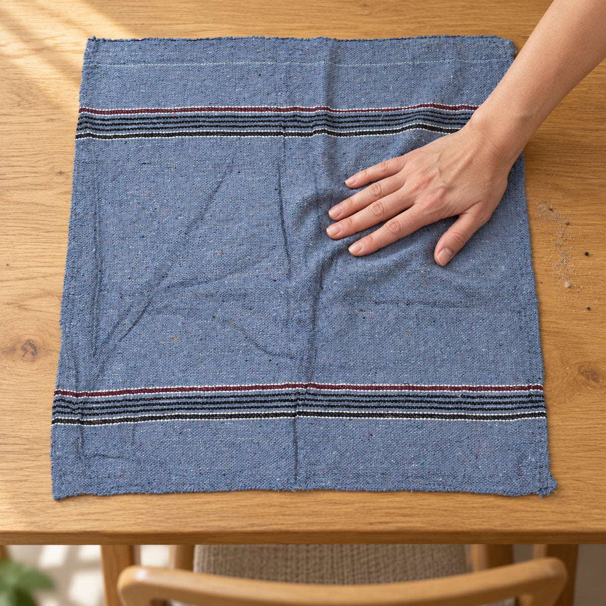 Woven cleaning cloth wiping a table