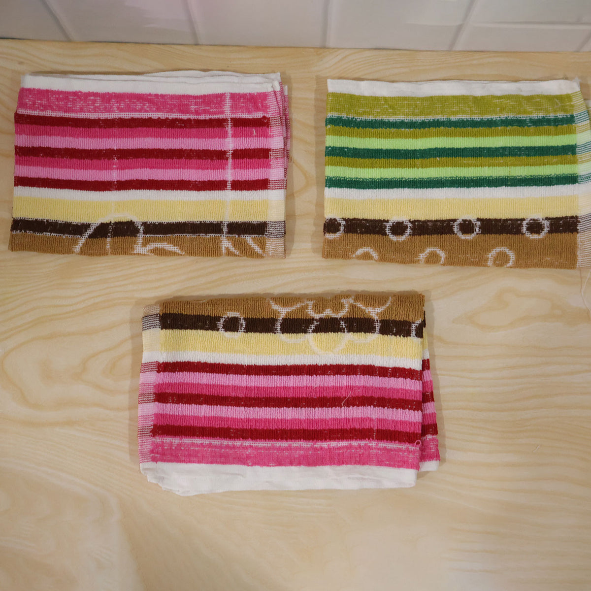 Actual photograph of three folded striped cleaning cloths