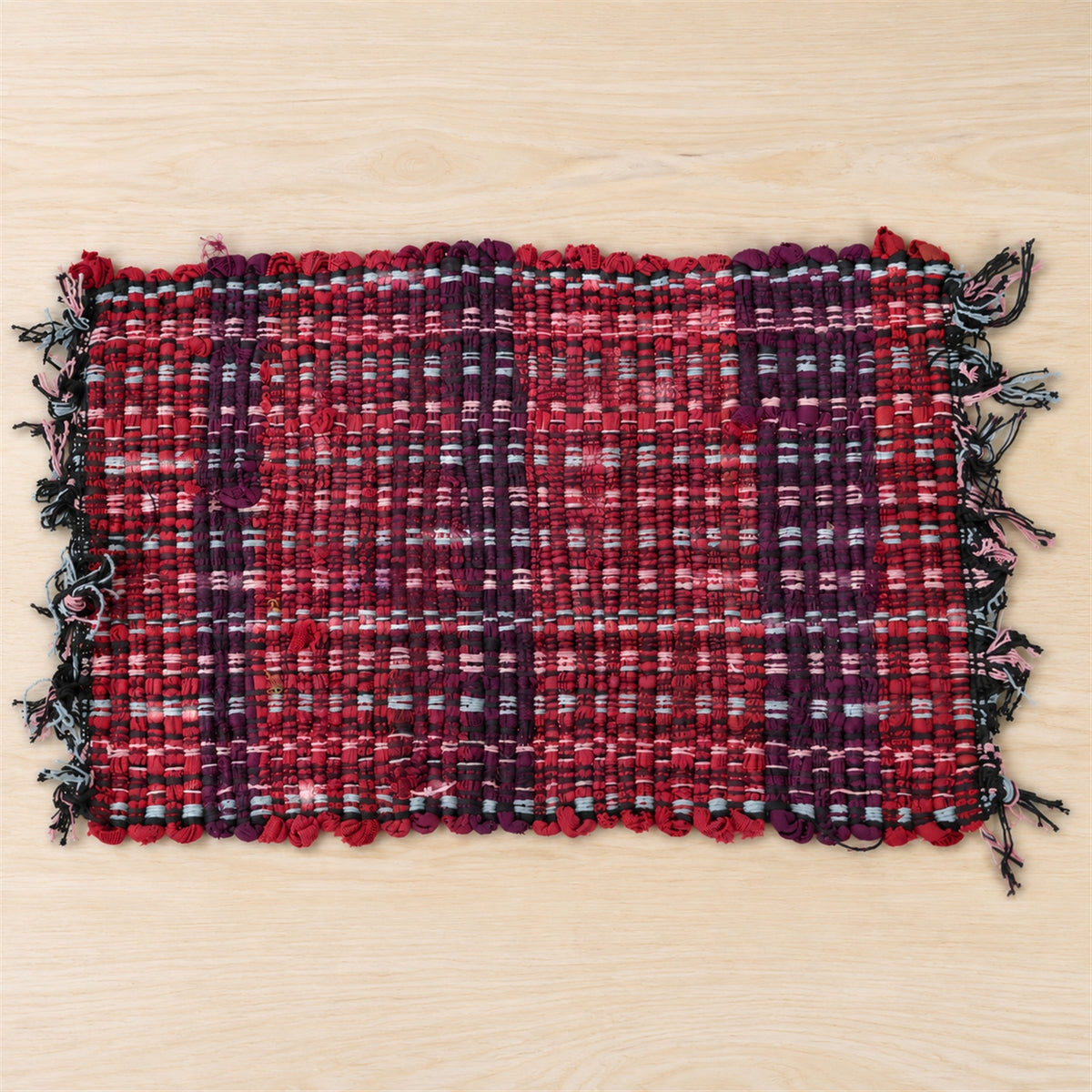 Actual photograph of woven floor mat with fringed edges