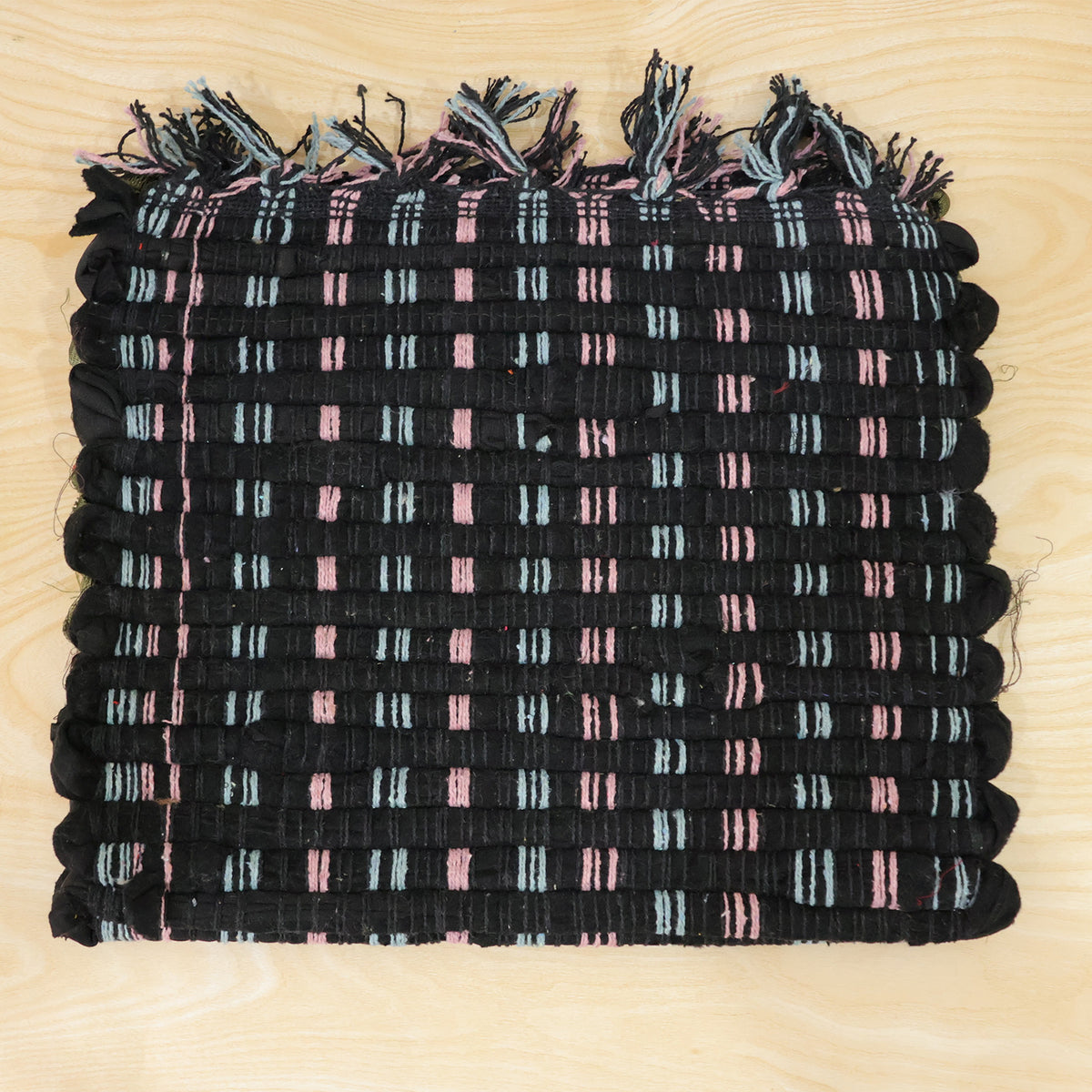 Actual photograph of woven floor mat with tassel edges