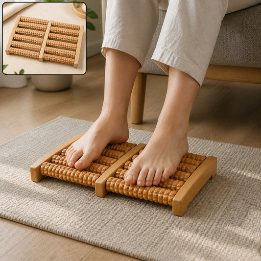 A person's bare feet rest on a light brown wooden foot massager with textured rollers on a grey rug.