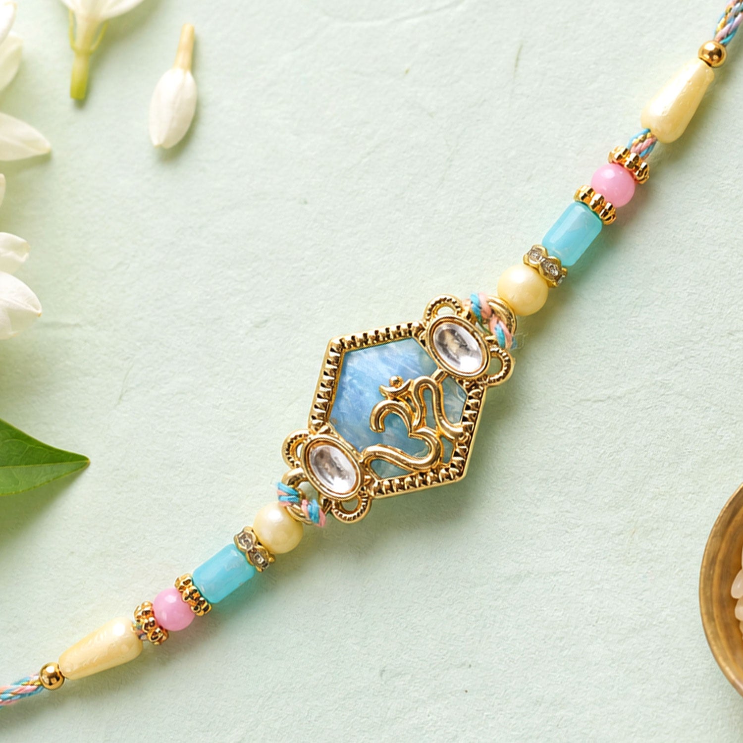 Om Hexagon Pendant Rakhi with Blue Enamel and Kundan Stones