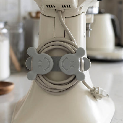 Self adhesive wall hook cable organizer on kitchen appliance