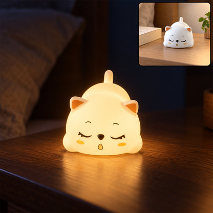 Sleeping cat night light glowing on a bedside table