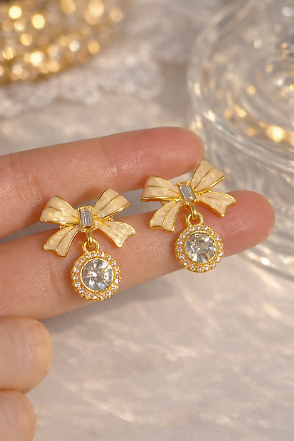 Pair of elegant bow crystal drop earrings displayed vertically
