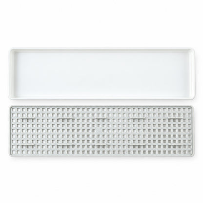 Plastic drain rack components on white background