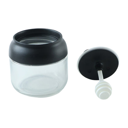 Round glass oil and honey dispenser on white background