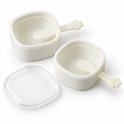 Two empty white square silicone molds with paw-shaped sticks and a clear lid are arranged on a white background.