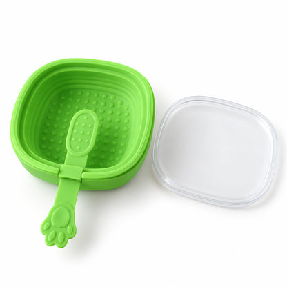 A bright green silicone ice cream mold with a paw-shaped stick and a clear lid rests on a white surface.