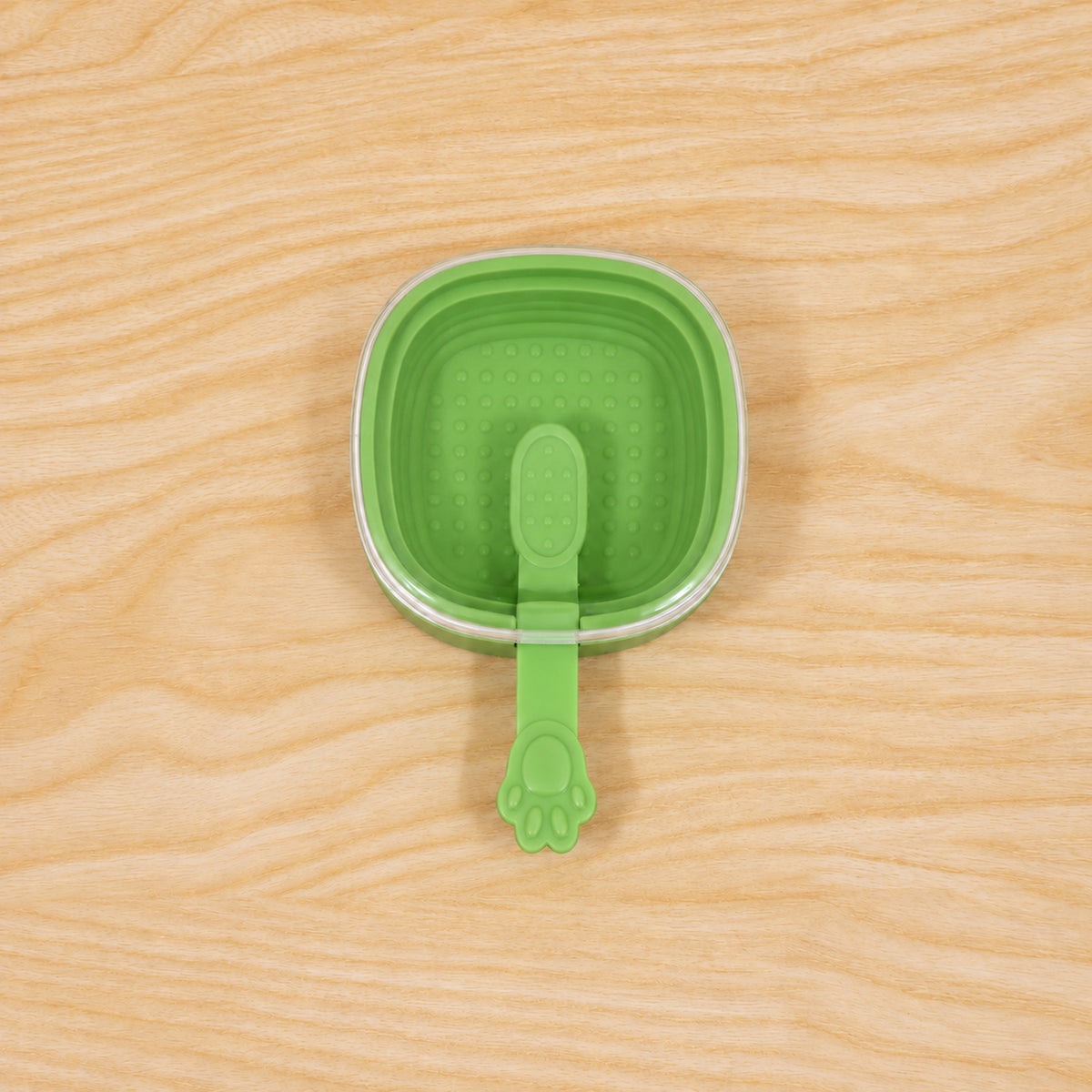 Green silicone ice cream pop mold with ingredients around it