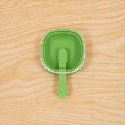 Green silicone ice cream pop mold with ingredients around it