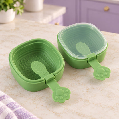 Two empty green square molds with paw-shaped handles are displayed on a speckled countertop in a kitchen setting.