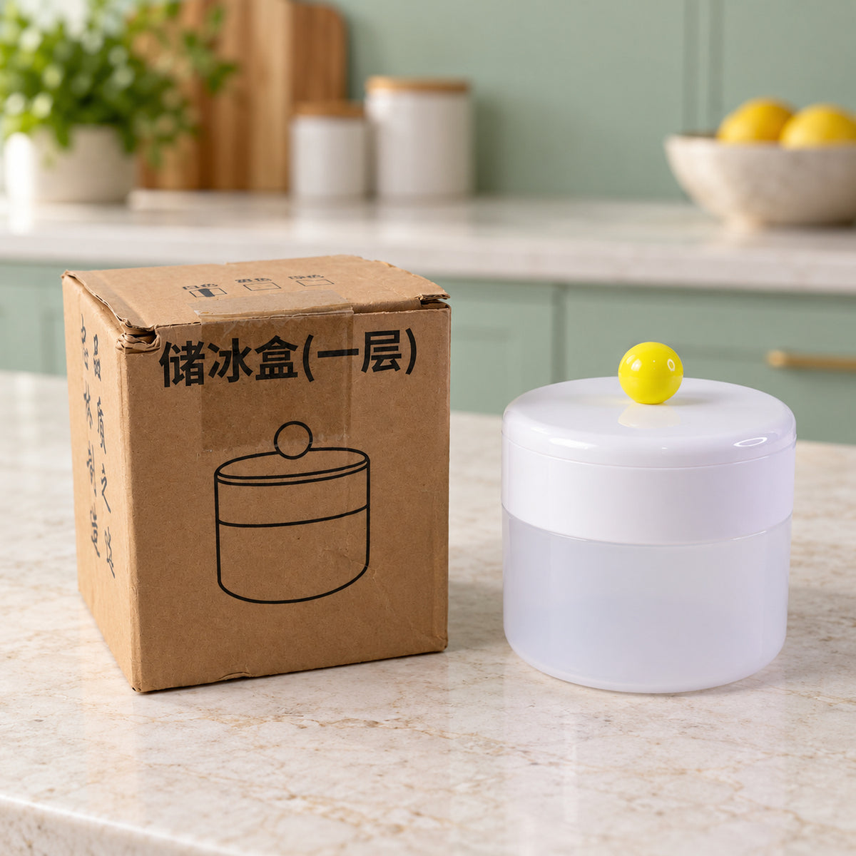 The assembled ice cube maker sits on a kitchen counter next to its brown cardboard packaging with a simple line drawing.
