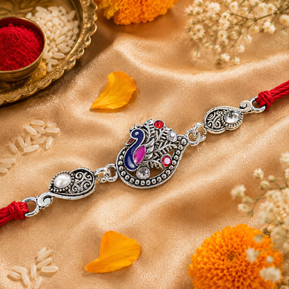 Silver-Toned Peacock Rakhi with Pink-Blue Enamel, Crystal Accents & Red Thread for Brother