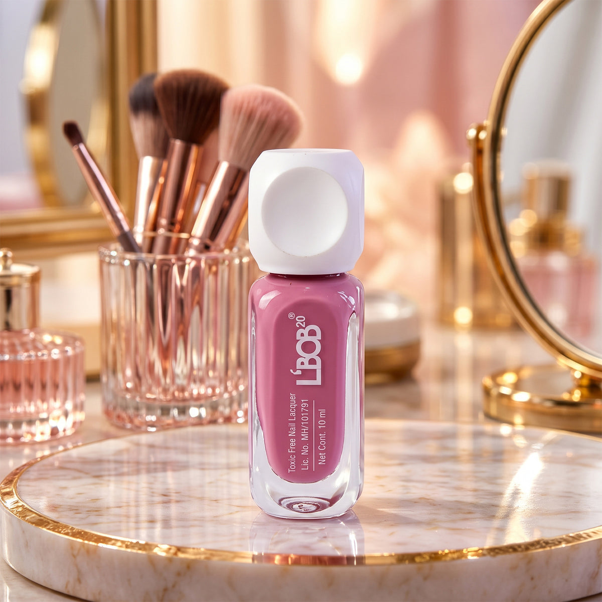 A bottle of mauve nail polish on a marble tray, surrounded by makeup brushes and a mirror.