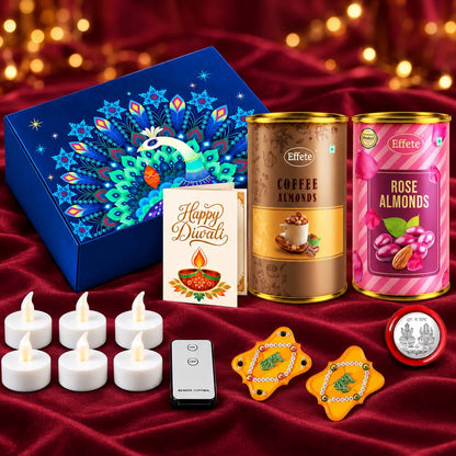 A collection of Diwali gifts including a blue peacock box, two almond tins, a card, LED lights, and yellow decor.