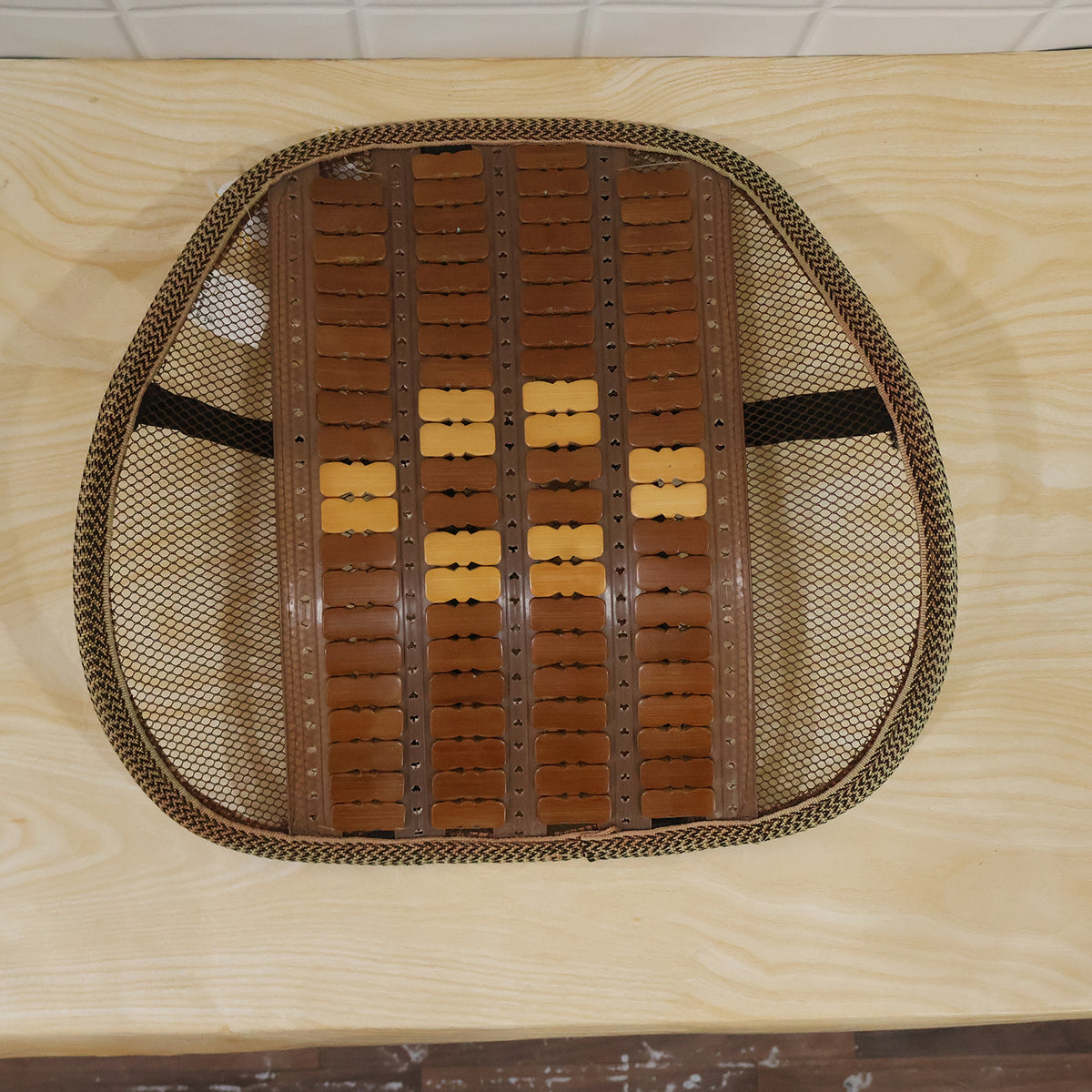 Mesh seat back support with wooden bead panel and securing strap live