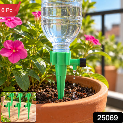 A green plastic plant watering spike with a clear water bottle inserted, dripping water into a terracotta pot with – view 8