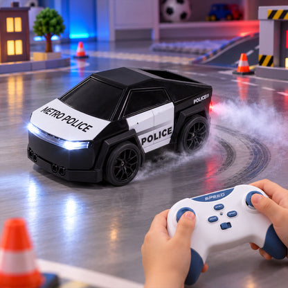 A child's hands hold a white and blue remote control, operating a black and white police car toy that emits mist while