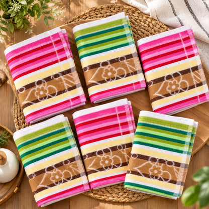 Six folded cloths with pink, white, green, and brown stripes and a floral pattern are arranged on a round woven mat.