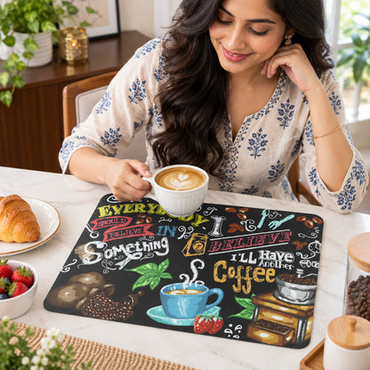 A woman smiles while holding a white coffee cup, with the coffee-themed mat on a light-colored table beside her.