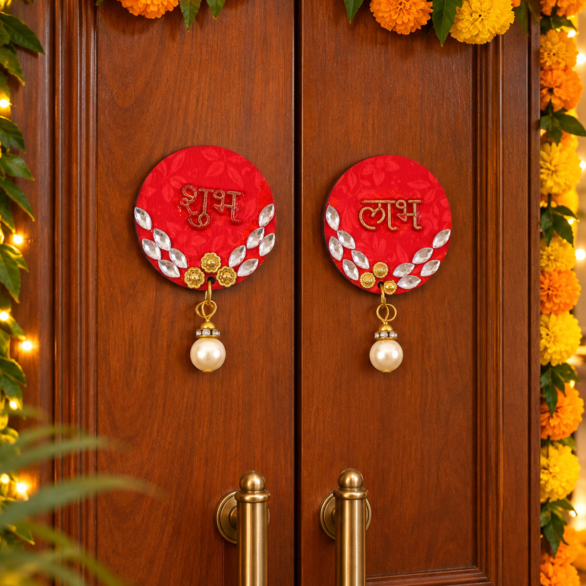 A pair of red circular Shubh Labh door decor pieces with pearl hangings adorn a wooden door, surrounded by marigold garlands.