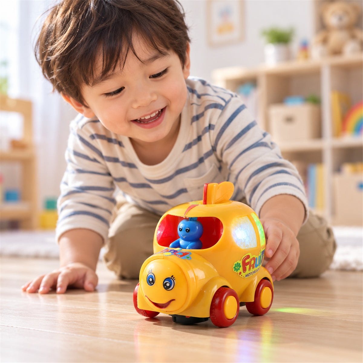 A young child with a striped shirt smiles while playing with a yellow musical car toy on a wooden floor.