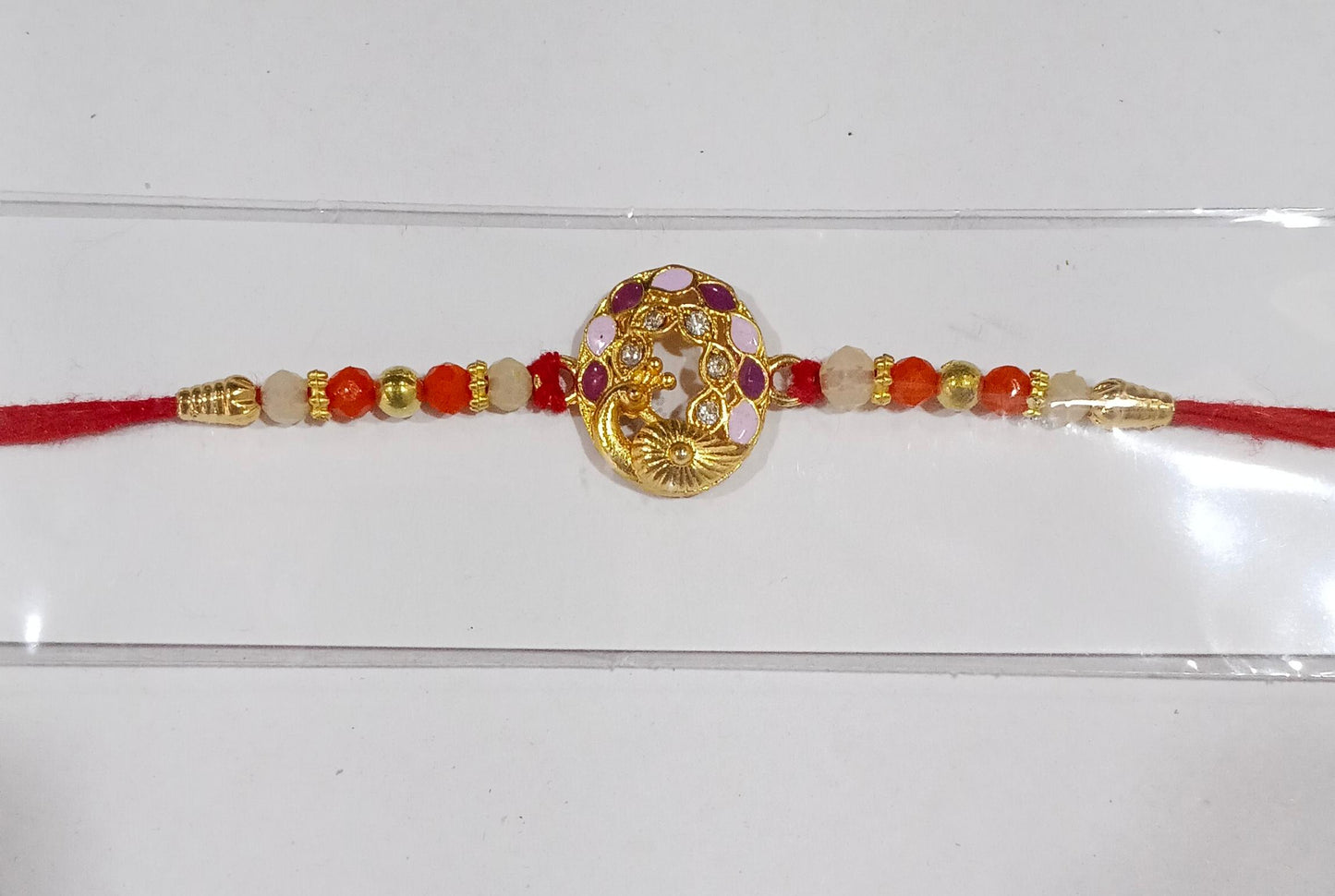 Peacock design rakhi with multicolor beads on white background