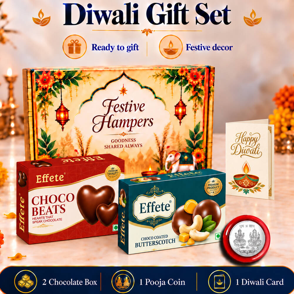 A festive hamper box with two chocolate boxes, a silver coin, and a Happy Diwali card on a table.