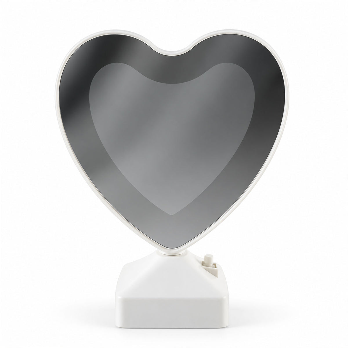 A heart-shaped mirror on a white base, reflecting a dark, subtle image, against a plain white background.