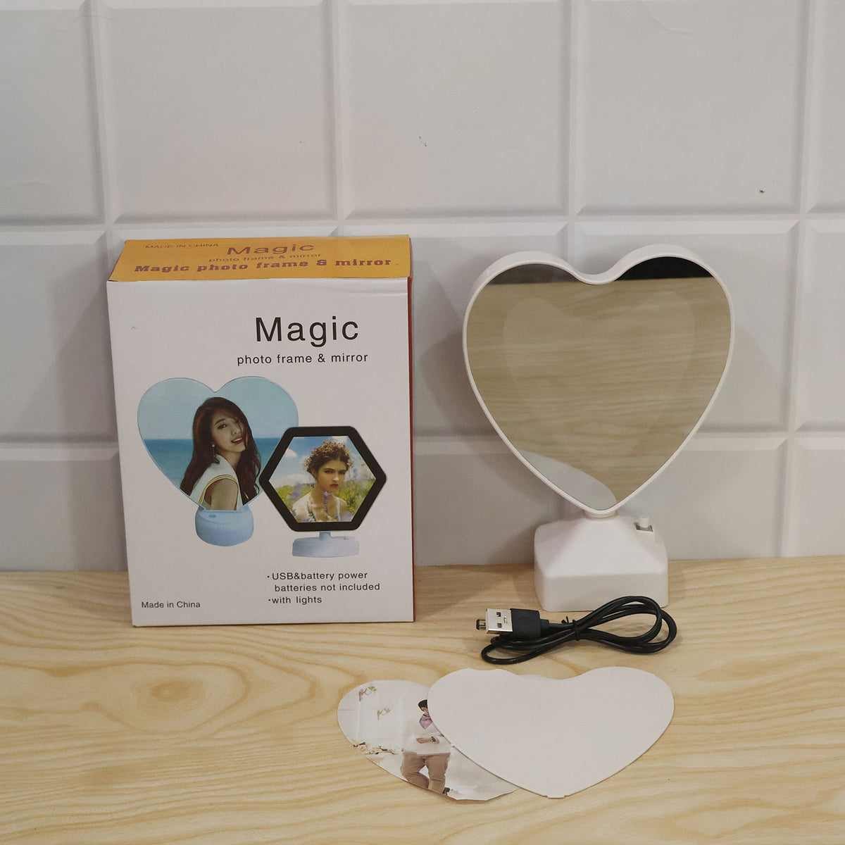 The heart mirror frame, USB cable, photo insert, backing plate, and product box arranged on a wooden surface.