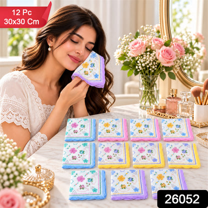 A woman holds a purple-edged floral handkerchief to her cheek, with a dozen colorful handkerchiefs arranged on a table
